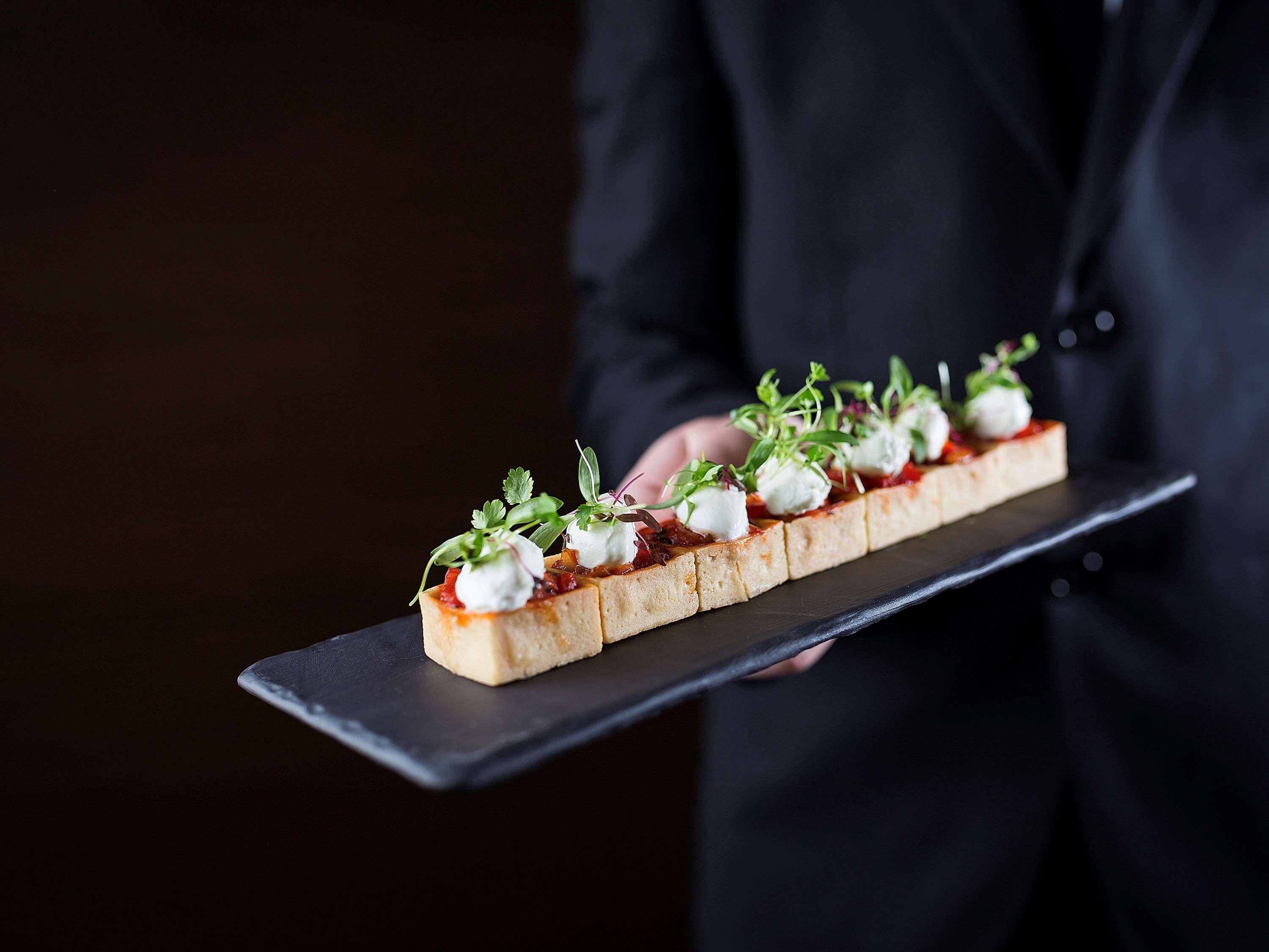 Pullman Sydney Olympic Park Hotel Bagian luar foto A server holding a plate of finger food