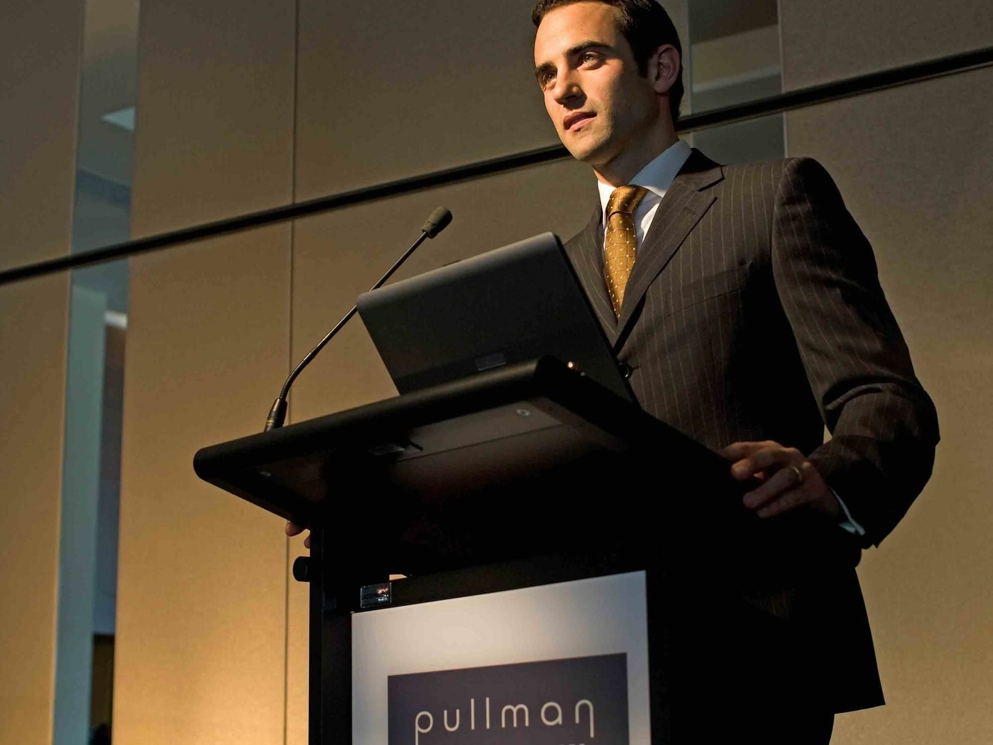 Pullman Sydney Olympic Park Hotel Bagian luar foto A man speaking at a podium